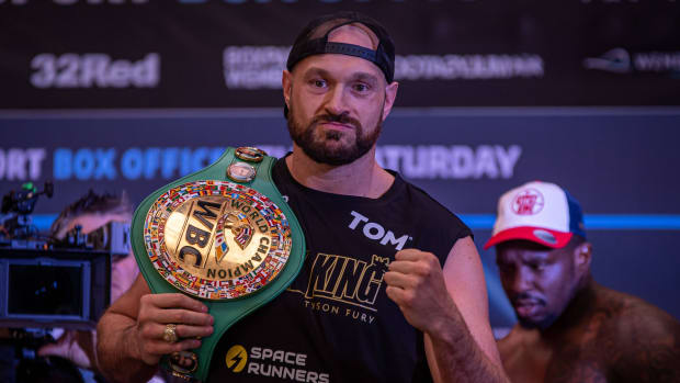 Boxer Tyson Fury poses for photos with the championship belt during his official weigh-in for his bout against Dillian Whyte.