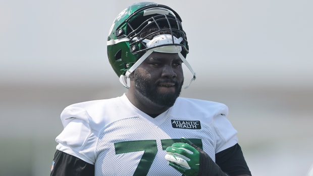 Jets offensive tackle Mekhi Becton (77) looks on during training camp practice.