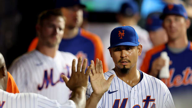 Aug 9, 2022; New York City, New York, USA; New York Mets starting pitcher Carlos Carrasco (59) is congratulated in the dugout by teammates after coming out of the game against the Cincinnati Reds during the seventh inning at Citi Field.