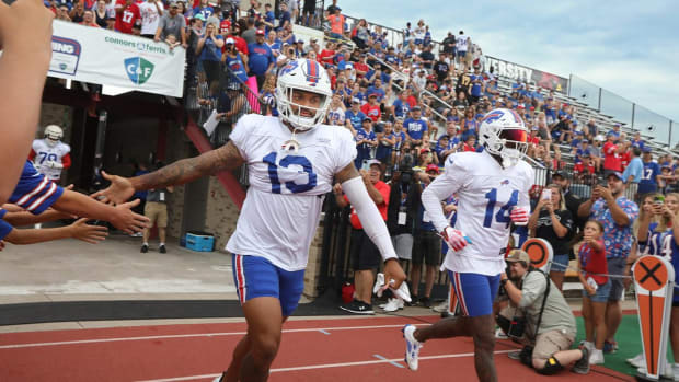 Bills receiver Gabe Davis (13), left, high-fives fans as he runs onto the field with Stefon Diggs (14), right, on day nine of Buffalo Bills training camp at St. John Fisher University in Rochester Thursday, Aug. 4, 2022.