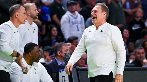 Tom Izzo laughs on Michigan State basketball sideline.