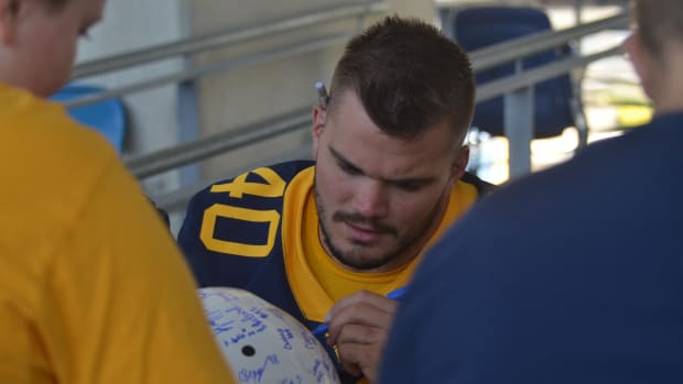 West Virginia linebacker Wil Schoonover signing autographs at WVU Fan Day.
