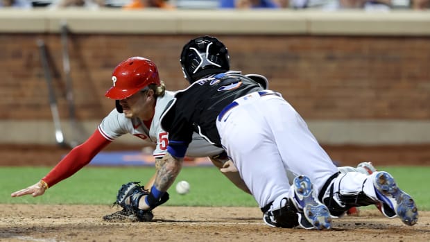 Aug 12, 2022; New York City, New York, USA; Philadelphia Phillies shortstop Bryson Stott (5) scores as he knocks the ball away from New York Mets catcher Tomas Nido (3) on a sacrifice fly by third baseman Alec Bohm (not pictured) during the tenth inning at Citi Field.