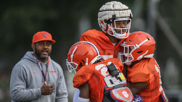 Clemson cornerbacks coach Mike Reed watches cornerback Malcolm Greene (21) and safety Kylon Griffin (18) lift linebacker Jeremiah Trotter Jr. (54) during practice in Clemson on Friday, August 12, 2022.