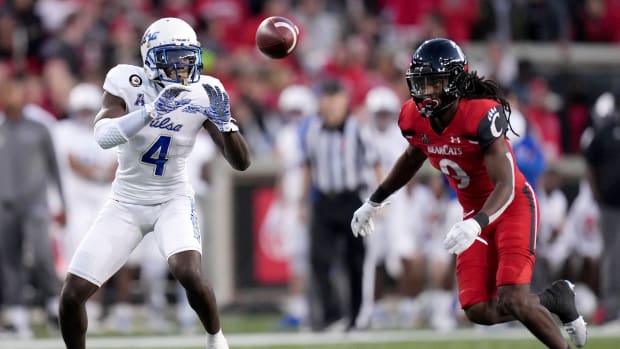 Tulsa receiver Josh Johnson (4) catches a pass as Cincinnati cornerback Arquon Bush (9) defends in the fourth quarter of the Bearcats' 28-20 win on Nov. 6. Syndication The Enquirer