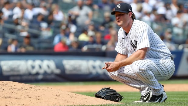 Yankees pitcher Gerrit Cole crouches beside the mound