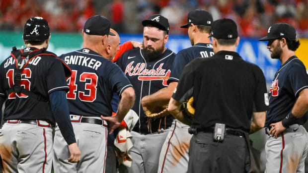 Braves relief pitcher Jackson Stephens (53) is checked on by a trainer and teammates after he was hit in the head by a line drive.
