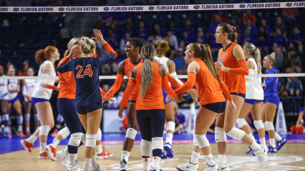 The Virginia volleyball team celebrates after scoring a point against the No. 15 Florida Gators on Saturday night in Gainesville, Florida.