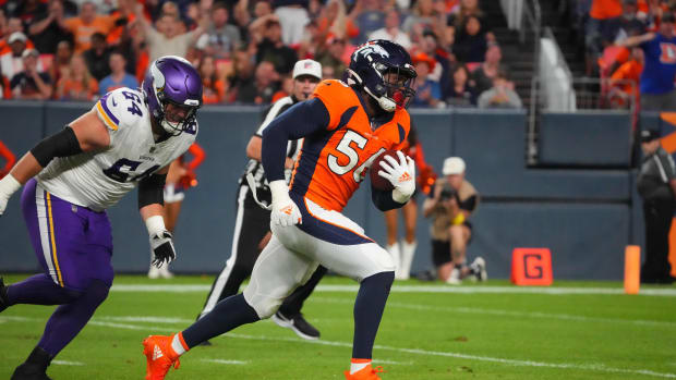 Denver Broncos linebacker Baron Browning (56) picks up a fumble and runs for a touchdown with Minnesota Vikings offensive tackle Blake Brandel (64) giving chase in the second quarter at Empower Field at Mile High.