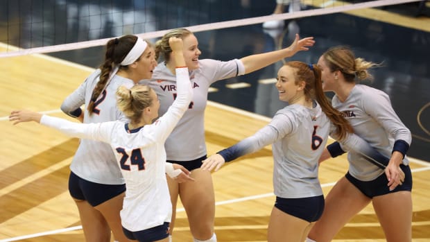 The Virginia volleyball team celebrates after scoring a point.