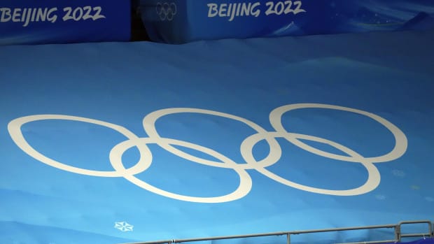 The Olympic rings printed on a matt on the side of a figure skating competition during the 2022 Olympics in Beijing.