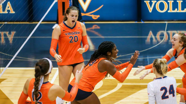 The Virginia Cavaliers volleyball team celebrates after a point against the Charlotte 49ers.
