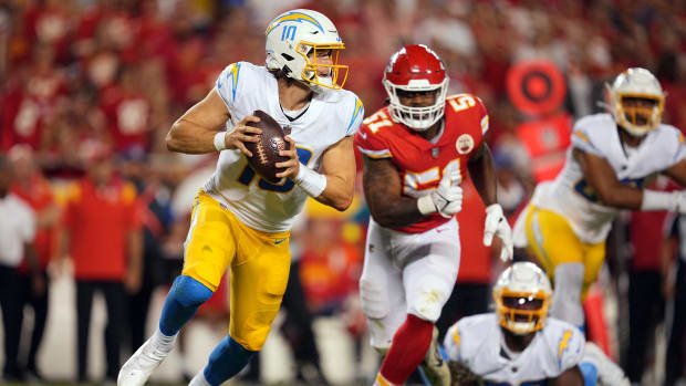 Sep 15, 2022; Kansas City, Missouri, USA; Los Angeles Chargers quarterback Justin Herbert (10) moves out to pass ahead of Kansas City Chiefs defensive end Mike Danna (51) during the second half at GEHA Field at Arrowhead Stadium. Mandatory Credit: Jay Biggerstaff-USA TODAY Sports