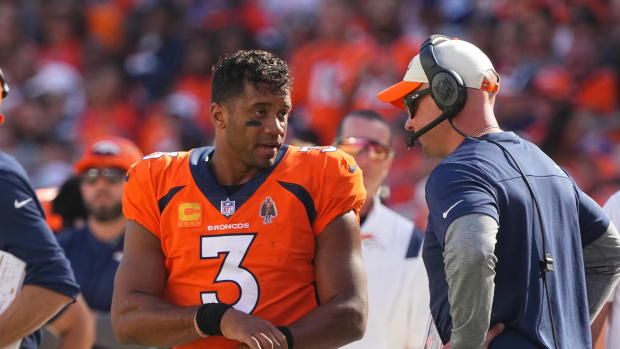 Denver Broncos head coach Nathaniel Hackett talks with Denver Broncos quarterback Russell Wilson (3) in the second quarter against the Houston Texans at Empower Field at Mile High.