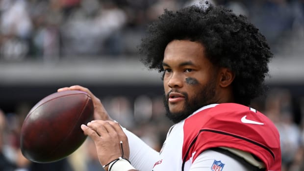 Cardinals quarterback Kyler Murray warms up on the sideline during the first half of an NFL football game against the Las Vegas Raiders.