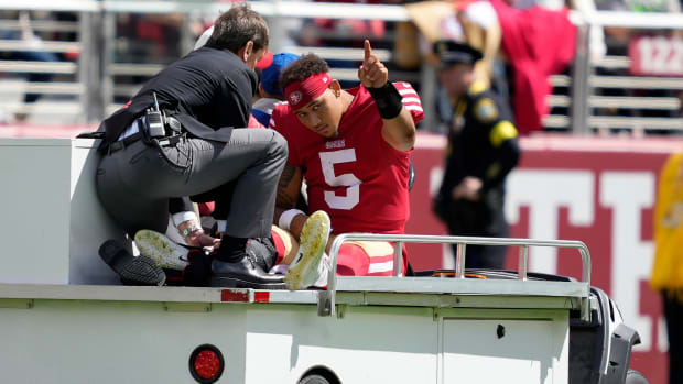 49ers quarterback Trey Lance (5) gestures while being carted off the field during the first half of an NFL football game against the Seattle Seahawks.