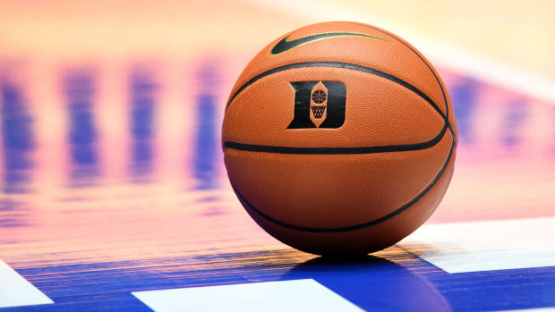 A basketball with a Duke logo sits on a court