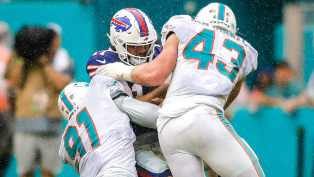 Josh Allen is tackled by two Dolphins players during a 2021 game