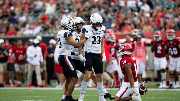 Cincinnati Bearcats wide receiver Drew Donley (23) celebrates after taking down Miami (Oh) Redhawks wide receiver Jalen Walker (14) during the third quarter of the NCAA football game between the Cincinnati Bearcats and the Miami RedHawks at Paycor Stadium in Cincinnati on Saturday, Sept. 17, 2022. The Cincinnati Bearcats defeated the Miami (Oh) Redhawks 38-17 in the 126th Battle for the Victory Bell. Cincinnati Bearcats Football Vs Miami Redhawks Sept 17 2022