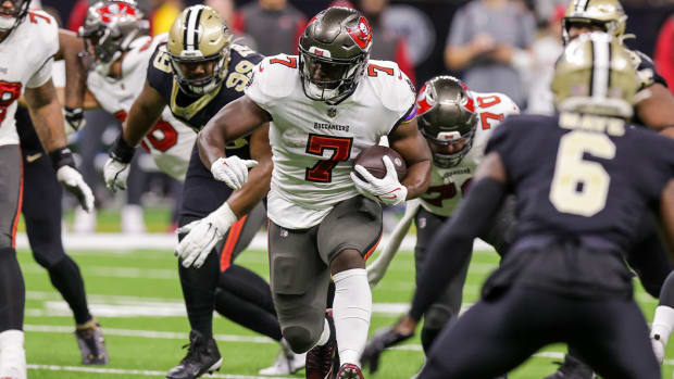 Sep 18, 2022; New Orleans, Louisiana, USA; Tampa Bay Buccaneers running back Leonard Fournette (7) runs against New Orleans Saints defensive tackle Shy Tuttle (99) and safety Marcus Maye (6) during the first half at Caesars Superdome.