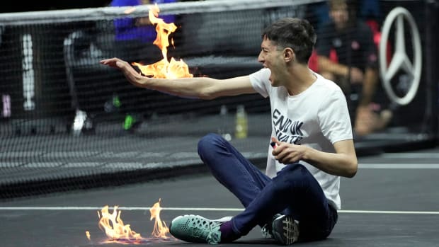 A man sets fire on his hand during protest at a match Team World’s Diego Schwartzman against Team Europe’s Stefanos Tsitsipas on day one of the Laver Cup tennis tournament at the O2 in London.