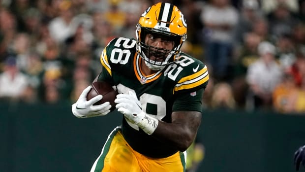 Packers running back AJ Dillon (28) carries the ball up field during the second half of an NFL football game against the Bears.