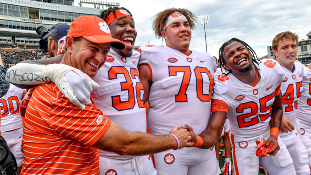 Clemson head coach Dabo Swinney, defensive tackle Etinosa Reuben (32), offensive lineman Tristan Leigh (70), and safety Jalyn Phillips (25) react after beating Wake Forest 51-45.