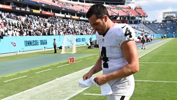 Derek Carr walks off the field after a loss to the Titans