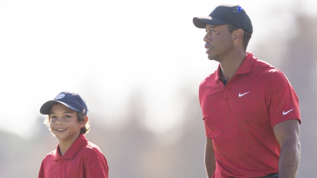 Charlie Woods and his dad Tiger Woods walk off the 13th green during the final round of the PNC Championship golf tournament on Dec. 19, 2021.