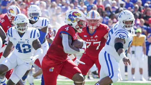 Sep 24, 2022; Lawrence, Kansas, USA; Kansas Jayhawks running back Devin Neal (4) runs the ball as Duke Blue Devils defensive tackle Ja'Mion Franklin (55) looks on during the first half of the game at David Booth Kansas Memorial Stadium. Mandatory Credit: Denny Medley-USA TODAY Sports