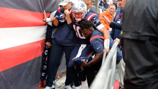 New England Patriots quarterback Mac Jones is helped off the field after suffering a leg injury vs. the Ravens.