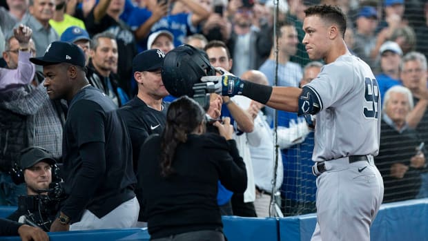New York Yankees designated hitter Aaron Judge (99) tips his helmet towards his mother after hitting his 61st home run scoring two runs against the Toronto Blue Jays during the seventh inning at Rogers Centre.