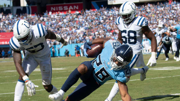 Tennessee Titans running back Jeremy McNichols (28) dives for extra yards past Indianapolis Colts outside linebacker Darius Leonard (53) and middle linebacker Bobby Okereke (58) during their game at Nissan Stadium Sunday, Sept. 26, 2021 in Nashville, Tenn.
