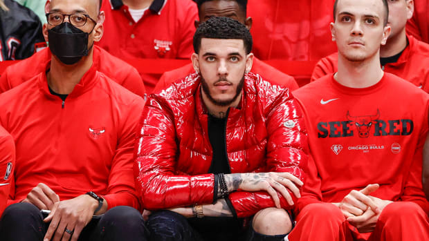Bulls guard Lonzo Ball (center) looks on from the bench during the second half of a playoff game.