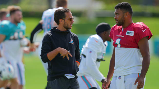 Coach Mike McDaniel speaks with Dolphins quarterback Tua Tagovailoa during practice.