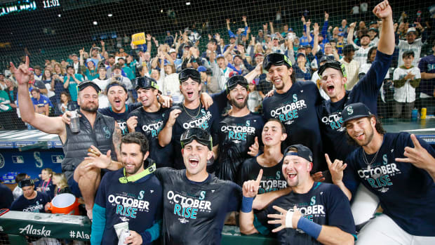 Sep 30, 2022; Seattle, Washington, USA; Seattle Mariners players and staff, including relief pitcher Matthew Boyd (first row, second from left) and catcher Cal Raleigh (first row second from right) celebrate in the dugout following a 2-1 victory against the Oakland Athletics to clinch a wild card playoff berth at T-Mobile Park.