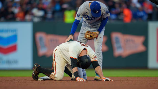 SF Giants first baseman Brandon Belt stays on the ground after an ugly slide into second base in front of Dodgers infielder Trea Turner. (2022)