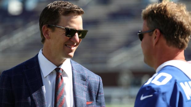 Eli Manning talks with Ole Miss head coach Lane Kiffin before a Rebels game in 2021.