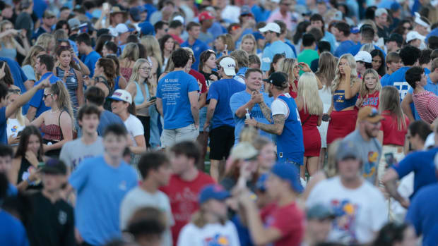 Fans storm the field at David Booth Kansas Memorial Stadium after Kansas defeated Iowa State 14-11