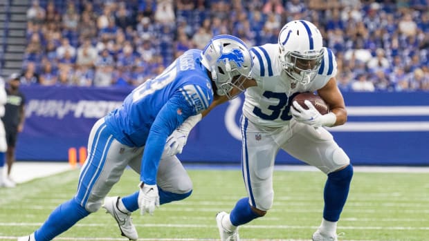 Indianapolis Colts running back Phillip Lindsay (30) runs the ball while Detroit Lions safety JuJu Hughes (33) defends in the first quarter at Lucas Oil Stadium.