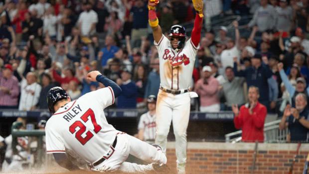 Atlanta Braves Ronald Acuna Jr. and Austin Riley score on a single hit by Travis d’Arnaud in the third inning of a baseball against the New York Mets, Sunday, Oct. 2, 2022, in Atlanta. (AP Photo/Hakim Wright Sr.)