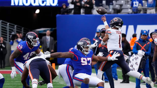 Oct 2, 2022; East Rutherford, New Jersey, USA; Chicago Bears quarterback Justin Fields (1) scrambles and throws the ball against the New York Giants during the second half at MetLife Stadium.