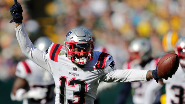 Oct 2, 2022; Green Bay, Wisconsin, USA; New England Patriots cornerback Jack Jones (13) celebrates after recovering a fumble by Green Bay Packers wide receiver Romeo Doubs (not pictured) at Lambeau Field.