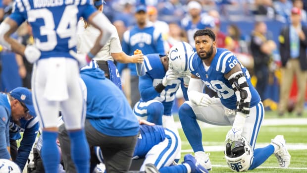 Oct 2, 2022; Indianapolis, Indiana, USA; Indianapolis Colts defensive tackle DeForest Buckner (99) takes a knee while Indianapolis Colts linebacker Shaquille Leonard (53) is bleeding on the field during the second quarter against the Tennessee Titans at Lucas Oil Stadium.