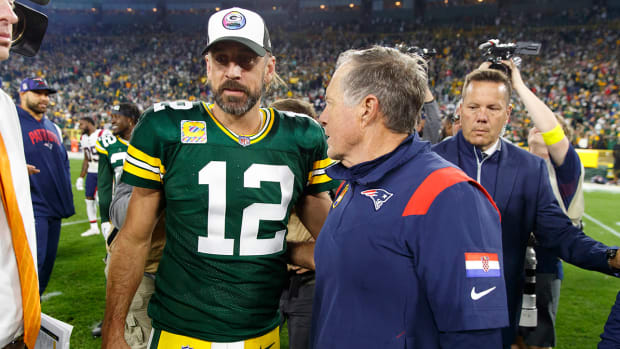 Packers quarterback Aaron Rodgers (12) talks with Patriots coach Bill Belichick following the game at Lambeau Field.