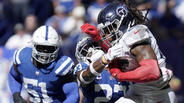Tennessee Titans running back Derrick Henry (22) stiff arms Indianapolis Colts cornerback Kenny Moore II (23) during the first half at Lucas Oil Stadium.