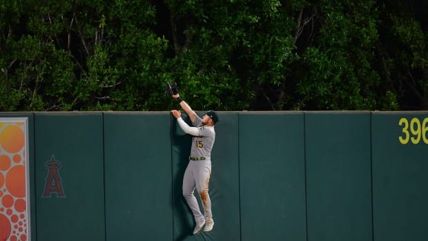 Sep 28, 2022; Anaheim, California, USA; Oakland Athletics center fielder Seth Brown (15) is unable to catch the solo home run of Los Angeles Angels center fielder Mike Trout (27) during the fourth inning at Angel Stadium. Mandatory Credit: Gary A. Vasquez-USA TODAY Sports