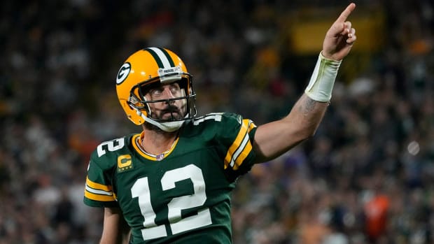 Packers quarterback Aaron Rodgers (12) celebrates after rushing for a first down.