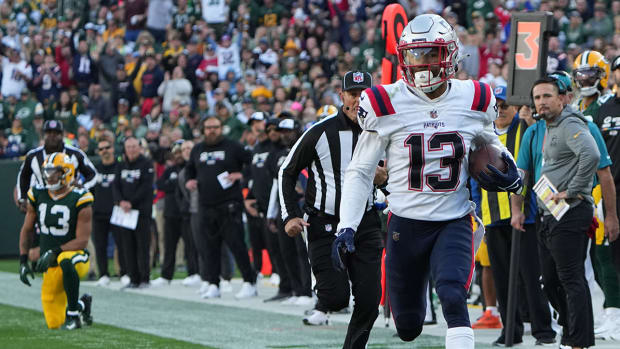 Patriots defensive back Jack Jones returns an interception thrown by Packers quarterback Aaron Rodgers for a touchdown.