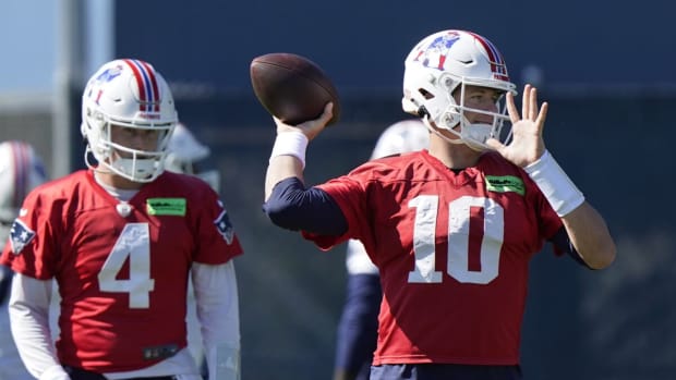 New England Patriots quarterback Mac Jones (10) winds up to pass as quarterback Bailey Zappe (4) looks on during an NFL football practice, Thursday, Oct. 6, 2022